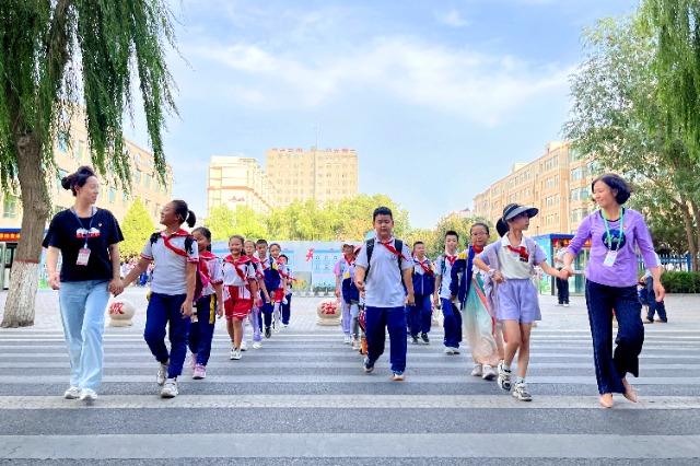 01 臨澤縣城關(guān)小學(xué)“紅燭先鋒”護(hù)學(xué)崗教師護(hù)送學(xué)生放學(xué)。謝靜 攝.jpg