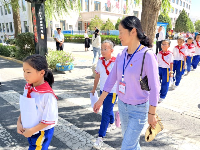 02 臨澤縣城關(guān)小學(xué)“紅燭先鋒”護(hù)學(xué)崗教師護(hù)送學(xué)生放學(xué)。謝靜 攝.jpg