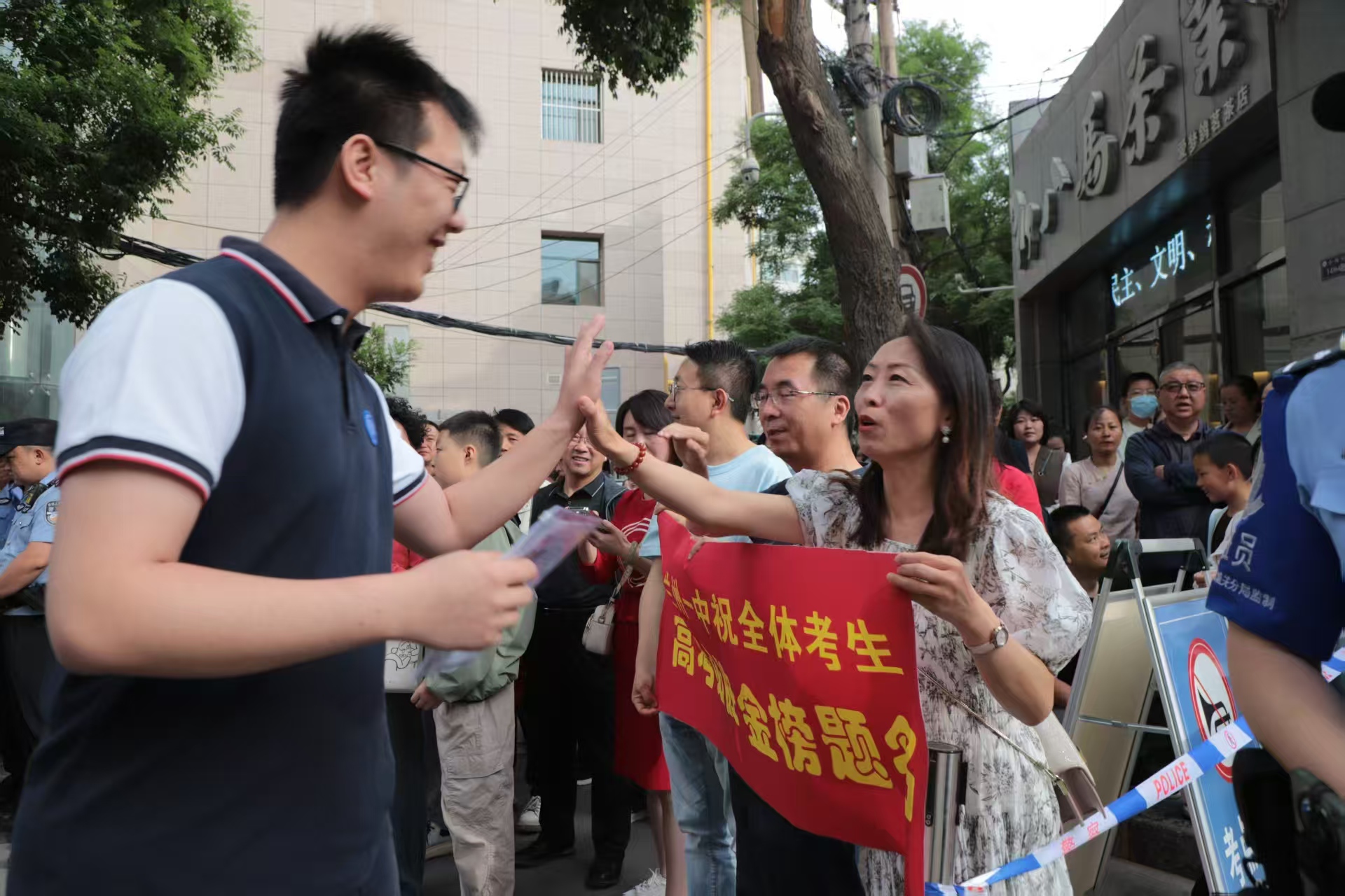 首場(chǎng)考試開(kāi)考前，蘭州一中教師在考場(chǎng)外暖心陪考送祝福，鼓勵(lì)學(xué)生從容應(yīng)對(duì)。（馬綺徽 攝）.jpg